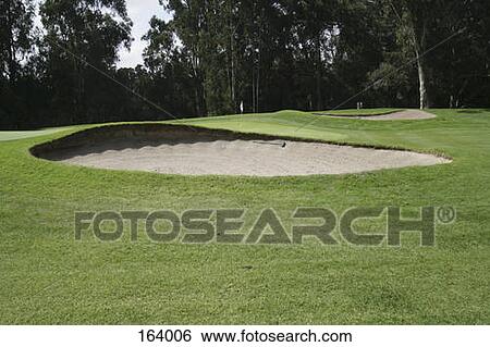 A sand trap in front of a green on a golf course View Large Photo Image Stock Photograph - A sand trap in front of a green on a golf course. Fotosearch