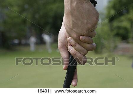 Stock Image - Close up of a golfer holding a club. Fotosearch