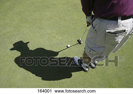 Stock Image - High angle view of a golfer putting. Fotosearch