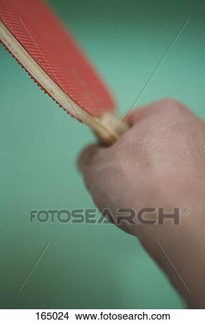 Picture - A person holding a ping pong paddle, close up. Fotosearch