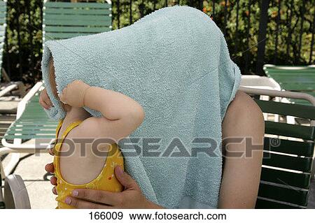 A baby and a parent hiding their faces under a towel View Large Photo Image Stock Photo - A baby and a parent hiding their faces under a towel. Fotosearch