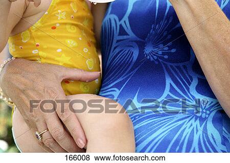 Midsection of a woman holding a baby View Large Photo Image Stock Photo - Midsection of a woman holding a baby. Fotosearch