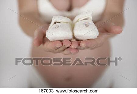 A pregnant woman in her underwear holding baby shoes View Large Photo Image Stock Image - A pregnant woman in her underwear holding baby shoes. Fotosearch