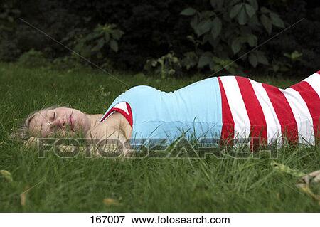 A pregnant woman sleeping in the grass View Large Photo Image Stock Photo - A pregnant woman sleeping in the grass. Fotosearch