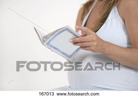 Midsection of a pregnant woman reading a medical record View Large Photo Image Stock Image - Midsection of a pregnant woman reading a medical record. Fotosearch