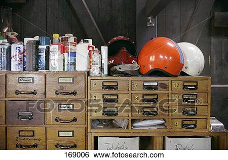 Bottles and helmets arranged above wooden drawers View Large Photo Image Stock Photograph - Bottles and helmets arranged above wooden drawers. Fotosearch