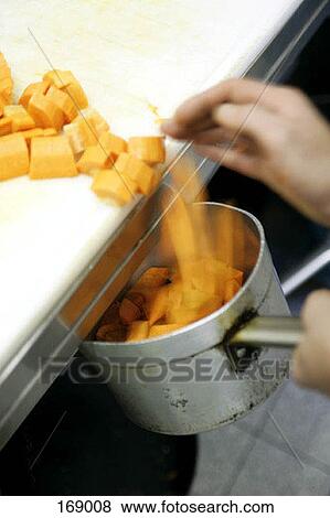 Carrots being swept into a pot View Large Photo Image Stock Photo - Carrots being swept into a pot. Fotosearch
