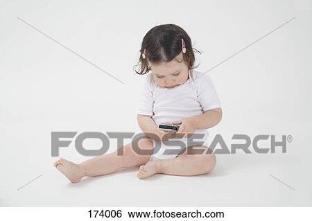 A baby holding a cell phone View Large Photo Image Stock Photograph - A baby holding a cell phone. Fotosearch