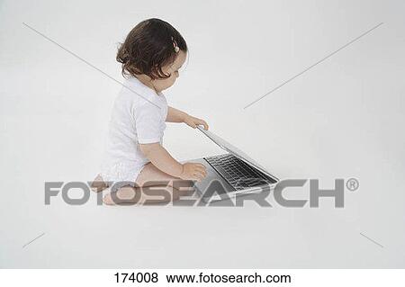 A baby playing with a laptop View Large Photo Image Stock Photo - A baby playing with a laptop. Fotosearch