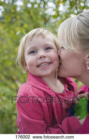 A mother kissing her daughter, smiling View Large Photo Image Stock Image - A mother kissing her daughter, smiling. Fotosearch