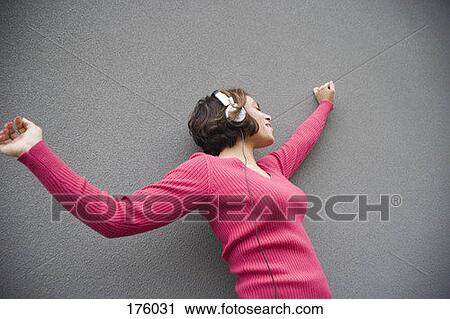 A young woman wearing headphones, dancing View Large Photo Image Stock Image - A young woman wearing headphones, dancing. Fotosearch
