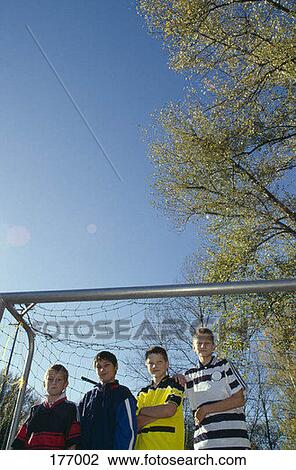 A group of boys standing in a soccer goal View Large Photo Image Stock Image - A group of boys standing in a soccer goal. Fotosearch
