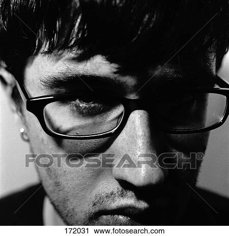 Young man with glasses and head down View Large Photo Image Stock Image - Young man with glasses and head down. Fotosearch