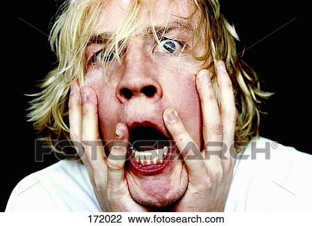 Young man with head in hands and mouth open View Large Photo Image Stock Image - Young man with head in hands and mouth open. Fotosearch