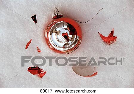Stock Photo - Close-up of Christmas decoration in snow with shattered pieces. Fotosearch