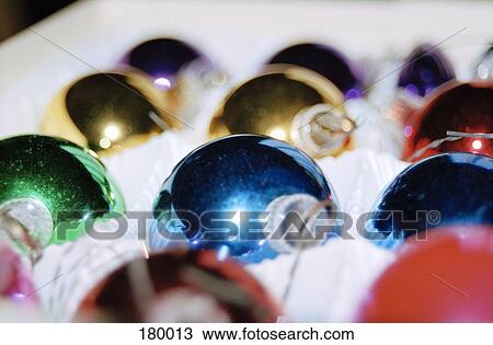 Stock Image - Close-up of multi colored Christmas decorations in snow. Fotosearch