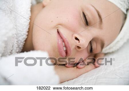 Young woman in bathrobe lying on front with eyes closed View Large Photo Image Stock Image - Young woman in bathrobe lying on front with eyes closed. Fotosearch