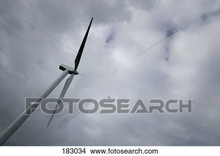 Wind turbine and airplane flying in distance View Large Photo Image Picture - Wind turbine and airplane flying in distance. Fotosearch