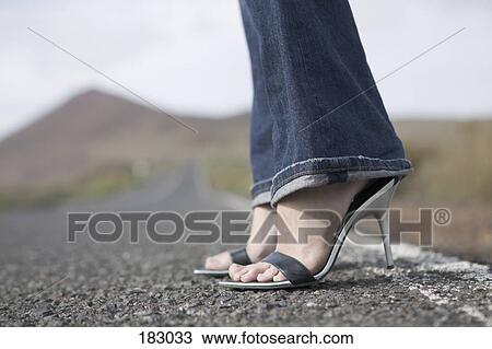 Young woman stands waiting by roadside View Large Photo Image Stock Image - Young woman stands waiting by roadside. Fotosearch