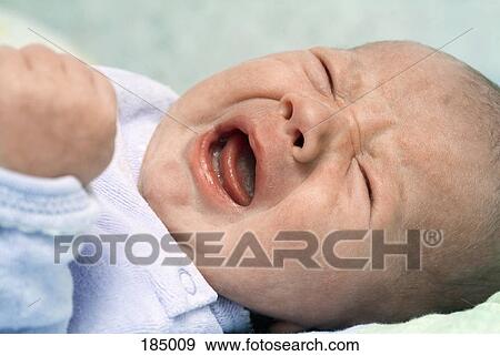 Stock Photo - Newborn baby lying on its back crying. Fotosearch