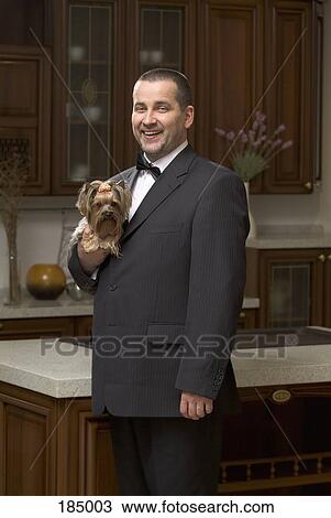 Side view of man dressed in suit and holding lap dog View Large Photo Image Stock Image - Side view of man dressed in suit and holding lap dog. Fotosearch