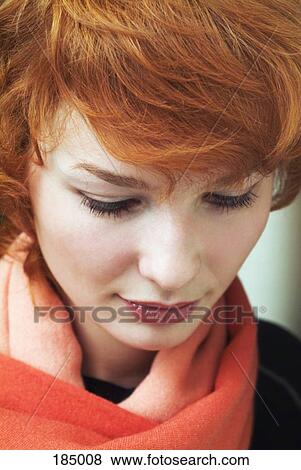 Young woman with red hair looking down View Large Photo Image Stock Photo - Young woman with red hair looking down. Fotosearch