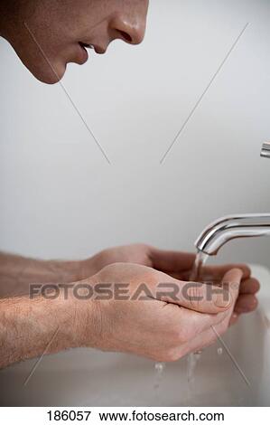 Man cupping hands under faucet View Large Photo Image Stock Photo - Man cupping hands under faucet. Fotosearch