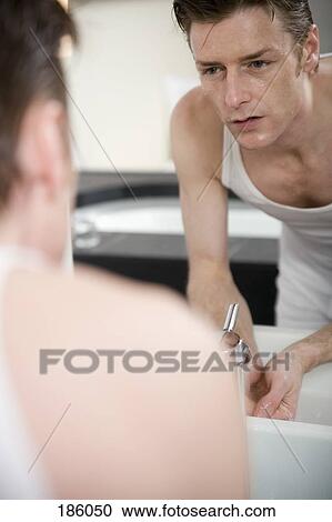 Man washing face and looking in mirror View Large Photo Image Stock Image - Man washing face and looking in mirror. Fotosearch