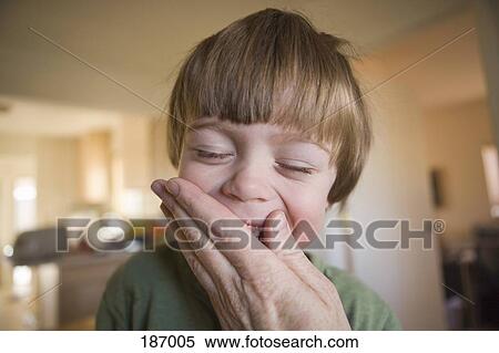 Stock Photography - An adult hand covering a young boys mouth. Fotosearch