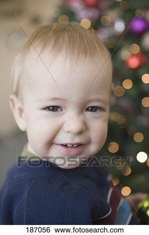 Baby boy smiling near Christmas tree View Large Photo Image Stock Photograph - Baby boy smiling near Christmas tree. Fotosearch