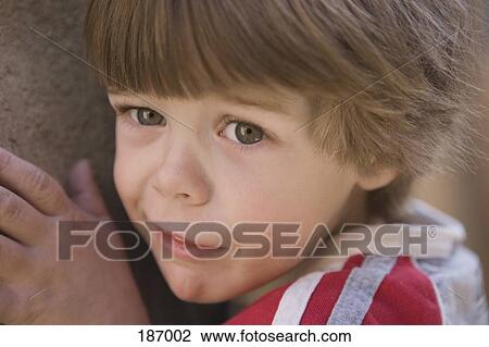 Boy standing up against wall looking afraid View Large Photo Image Stock Image - Boy standing up against wall looking afraid. Fotosearch