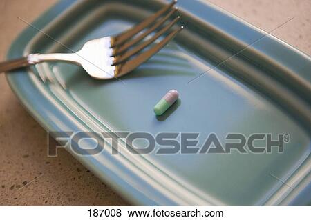 Capsule and fork on plate View Large Photo Image Stock Photo - Capsule and fork on plate. Fotosearch