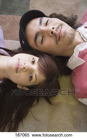 Teenage couple lying on floor View Large Photo Image Stock Photography - Teenage couple lying on floor. Fotosearch