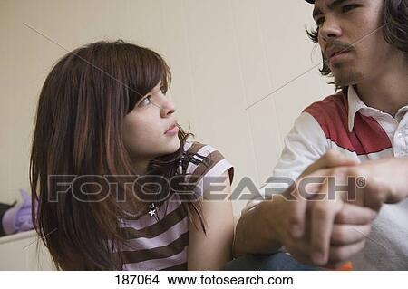 Teenage couple sitting and talking View Large Photo Image Picture - Teenage couple sitting and talking. Fotosearch