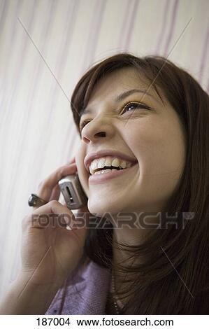 Teenage girl using mobile phone and laughing View Large Photo Image Picture - Teenage girl using mobile phone and laughing. Fotosearch