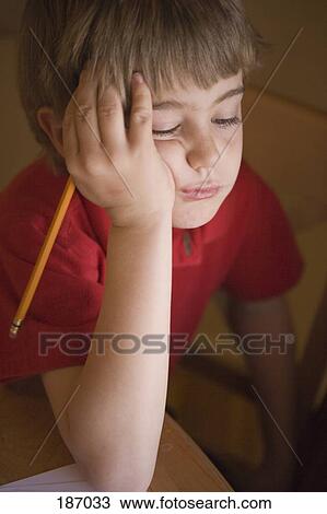Stock Image - Young boy doing homework. Fotosearch