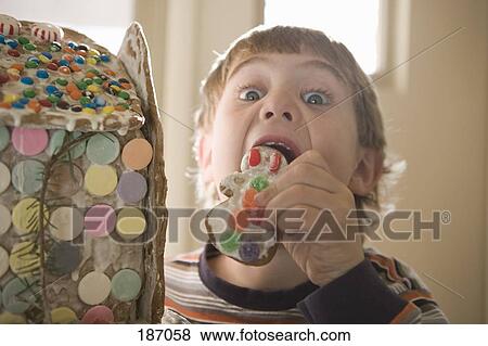 Young boy eating gingerbread cookie View Large Photo Image Stock Photo - Young boy eating gingerbread cookie. Fotosearch