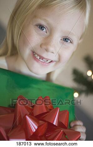 Young girl holding Christmas present View Large Photo Image Stock Image - Young girl holding Christmas present. Fotosearch