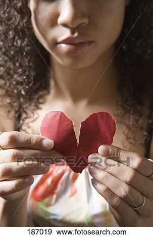 Young woman holding broken heart View Large Photo Image Stock Photo - Young woman holding broken heart. Fotosearch