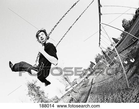 Two young men on swings in playground View Large Photo Image Picture - Two young men on swings in playground. Fotosearch