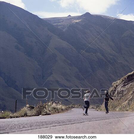 Two young men skateboarding down a steep road View Large Photo Image Stock Photo - Two young men skateboarding down a steep road. Fotosearch