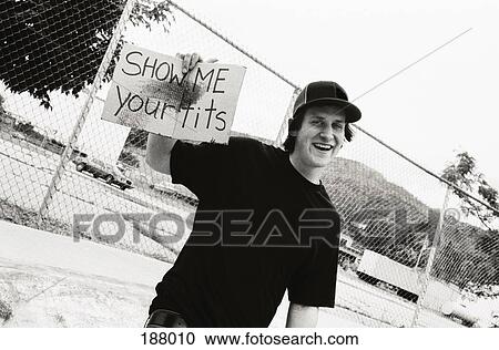 Stock Image - Young man holding cardboard sign. Fotosearch