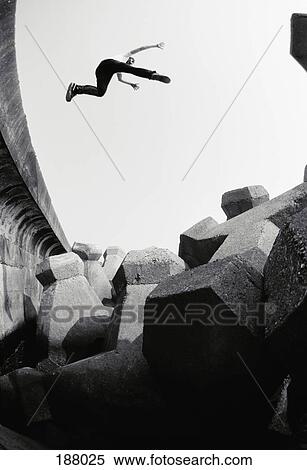 Young man leaping in mid-air with arms and legs outstretched View Large Photo Image Stock Photography - Young man leaping in mid-air with arms and legs outstretched. Fotosearch