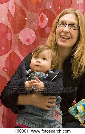Mother holding baby girl on lap View Large Photo Image Stock Image - Mother holding baby girl on lap. Fotosearch