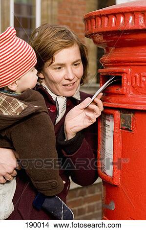 Picture - Mother holding son and sending letter, London, England. Fotosearch