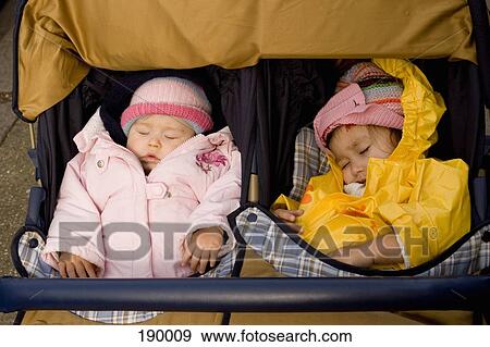 Two girls sleeping in baby stroller View Large Photo Image Stock Photo - Two girls sleeping in baby stroller. Fotosearch