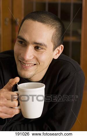 Stock Photograph - Man holding mug and smiling. Fotosearch