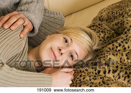Young woman lying down on sofa View Large Photo Image Stock Photo - Young woman lying down on sofa. Fotosearch