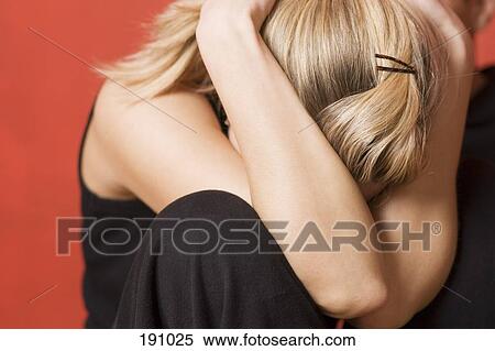 Stock Photography - Young woman sitting curled up with head down. Fotosearch