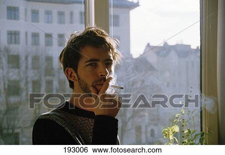 Stock Photograph - Young man smoking a cigarette. Fotosearch